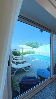 a view of a patio with lounge chairs and a pool at Al Mansi Luxury Retreat in Jazīrat al ‘Awwāmīyah