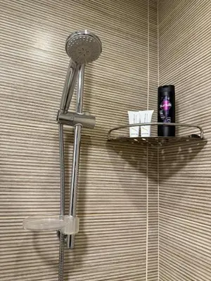a shower head on a wall with a shelf in a bathroom at 2BR G-Cribs in Hurghada