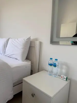 two bottles of water sitting on a nightstand next to a bed at 2BR G-Cribs in Hurghada