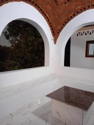 a room with two arched windows and a stone bench at Reagan House in Aswan