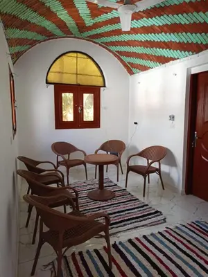 a group of chairs and tables in a room at Reagan House in Aswan