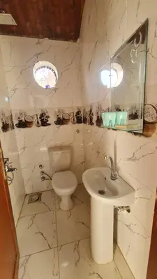 a white bathroom with a toilet and a sink at Reagan House in Aswan