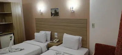 a hotel room with two twin beds and a chair at S S Luxor Hotel in Luxor