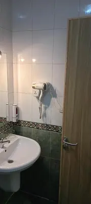 a bathroom with a sink and a toilet and a door at S S Luxor Hotel in Luxor