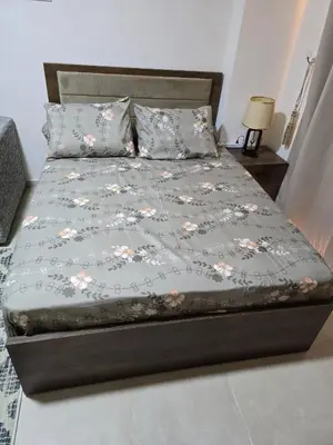 a bed with a gray bedspread with flowers on it at Golden Tiba in Hurghada