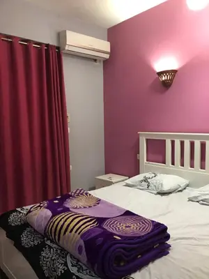 a bedroom with a bed with a purple wall at Ozera villa - west bank in Luxor