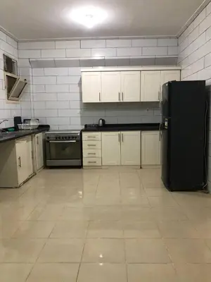a kitchen with white cabinets and a black refrigerator at Ozera villa - west bank in Luxor