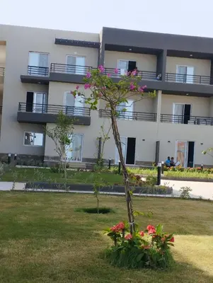 a building with a tree and flowers in a yard at Panorama View Sahl Hashesh Luxury Suite in Hurghada