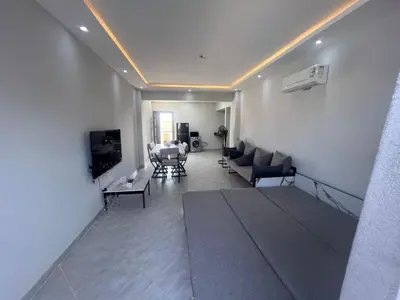 a living room with a couch and a tv at Panorama View Sahl Hashesh Luxury Suite in Hurghada