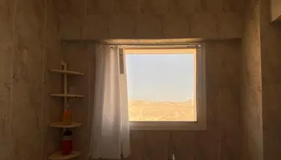 a window with a white curtain in a bathroom at Jana in Hurghada