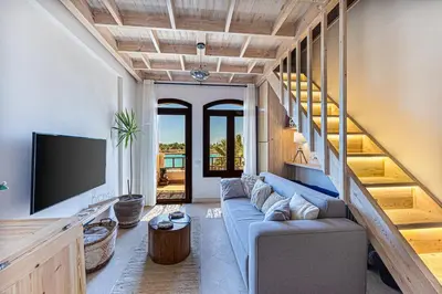 a living room with a blue couch and a tv at Peaceful Oasis, Stunning Views and Refreshing Pool, El Gouna in Hurghada