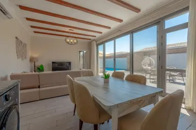 a kitchen and living room with a table and chairs at Lovely 2BR with Private Pool in Bali El Gouna in Hurghada