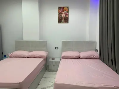 two beds in a room with pink sheets at Oasis marina in Hurghada