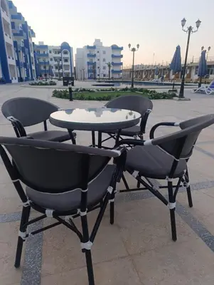 three chairs and a table in a courtyard at Oasis marina in Hurghada
