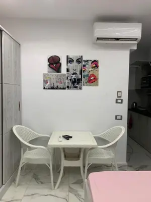 a white dining room with a table and chairs at Oasis marina in Hurghada