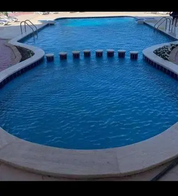 a large swimming pool with blue water in it at كمبوند كابتن in Hurghada