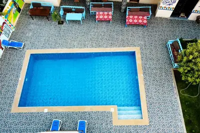 an overhead view of a swimming pool with tables and chairs at Luxor Hotel in Luxor