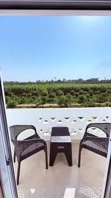 a patio with two chairs and a table on a balcony at Magic Garden House in Luxor