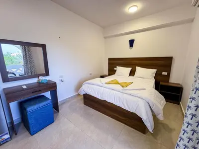 a bedroom with a large bed and a mirror at Magic Garden House in Luxor