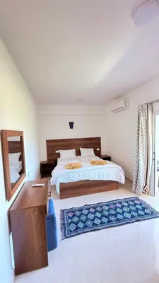a bedroom with a bed and a desk and a mirror at Magic Garden House in Luxor