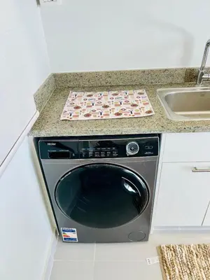 a washer and dryer in a kitchen next to a sink at Makadi Heights Luxury 1-BR App with Garden & Lagoon View in Hurghada