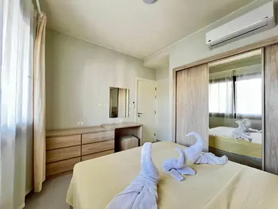 a bedroom with two beds and a mirror at Makadi Heights Luxury 1-BR App with Garden & Lagoon View in Hurghada