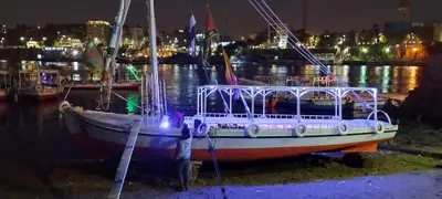 a boat sitting in the water at night at دندرة بوت in Aswān