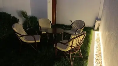 a group of chairs and a table in the grass at Relaxing Lodge in Luxor in ‘Ezbet Abu Ḥabashi