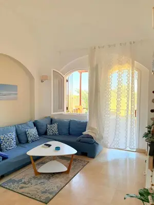 a living room with a blue couch and a table at El Gouna Stylish 2BR Italian Compound Beach Access in Hurghada
