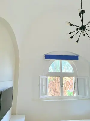 a window in a white room with a chandelier at El Gouna Stylish 2BR Italian Compound Beach Access in Hurghada