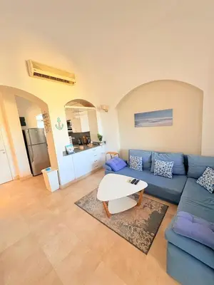 a living room with a blue couch and a table at El Gouna Stylish 2BR Italian Compound Beach Access in Hurghada