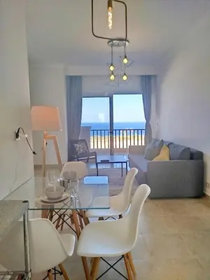 a living room with a table and chairs and a couch at Bay breeze in Hurghada