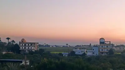 a group of buildings on a hill at sunset at Muhammad Ali house in Luxor