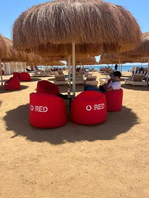 a person sitting in chairs under an umbrella on the beach at Luxury apartment With sea view and free beach in Hurghada