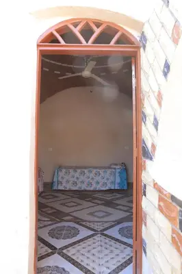 an opening in a room with a bed in it at House of Tranquility in Al Aqālitah