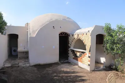 an outside view of a building with an arched doorway at House of Tranquility in Al Aqālitah