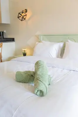 a stuffed teddy bear laying on a white bed at Ladybird - Veranda Loft in Hurghada