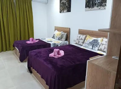 two beds with pink towels on them in a room at Tiba Golden in Hurghada