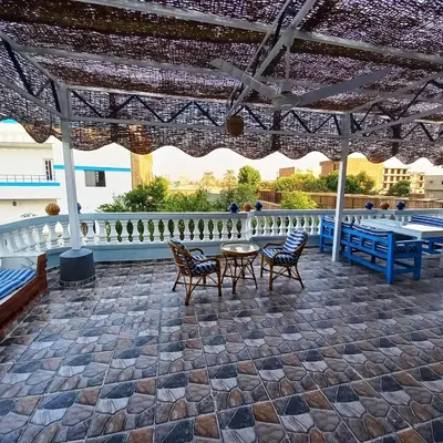 a patio with a table and chairs under a pavilion at Villa Nicole in Luxor