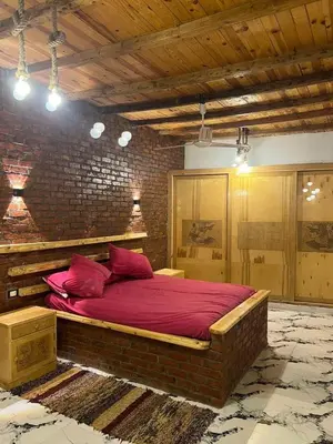 a bedroom with a large bed in a brick wall at Djorff studio in Al Aqālitah