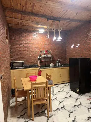 a kitchen with a wooden table with chairs and a counter at Djorff studio in Al Aqālitah
