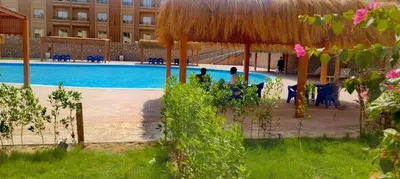 a large swimming pool with a building in the background at Bay View Resort in Hurghada