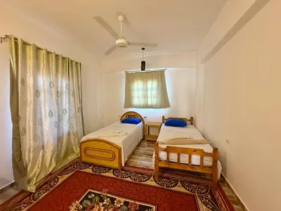 a bedroom with two beds and a window at El Fayrouz Guesthouse Luxor in Luxor