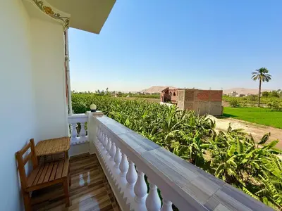 a balcony with a chair and a view of a field at El Fayrouz Guesthouse Luxor in Luxor
