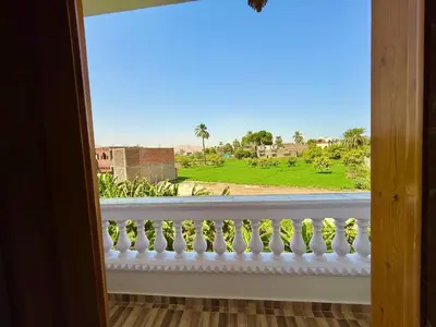 a window with a view of a green field at El Fayrouz Guesthouse Luxor in Luxor