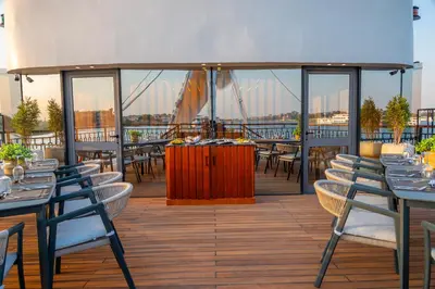 a restaurant with tables and chairs on a deck at Sonesta Dahabeya Amirat II - Nile Cruise Ship From Luxor to Aswan 4 nights in Luxor