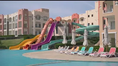 a pool with a water slide in a resort at Oyster Bay Beach Suites in Marsa Alam