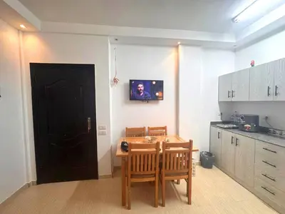 a kitchen with a table and chairs and a black door at Home 2 Bedroom in Hurghada in Hurghada
