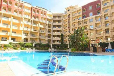 a swimming pool in front of a large building at Cozy Studio in Hurghada in Hurghada