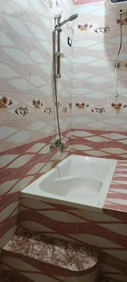 a bathroom with a bath tub with a shower at Family apartment LUXOR in Jazīrat al ‘Awwāmīyah